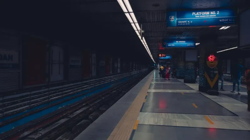 A dimly lit metro station platform with passengers waiting, showcasing urban public transportation.
