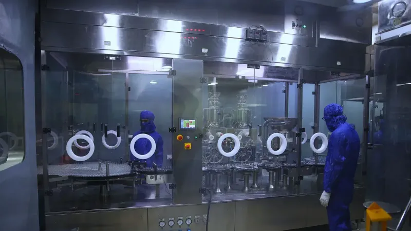Workers in protective gear inside a sterile pharmaceutical manufacturing plant in Rawalpindi, Pakistan.