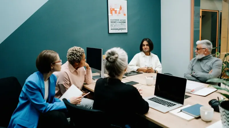 A diverse group of professionals engaged in a dynamic meeting in a modern office environment.