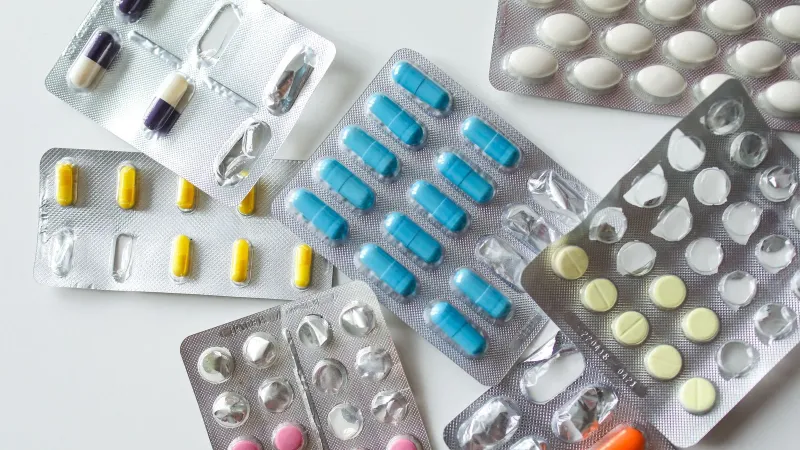 Colorful assortment of pills and capsules in blister packs for healthcare and medication usage.