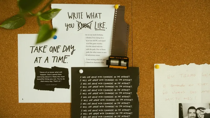 A corkboard with motivational quotes, notes, and film negatives, fostering creativity and reflection.