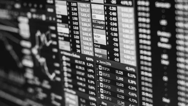 Monochrome image of stock market data on a screen, depicting financial information and trends.