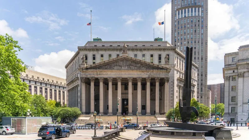 View of the historic New York County Courthouse with clear skies and cityscape.