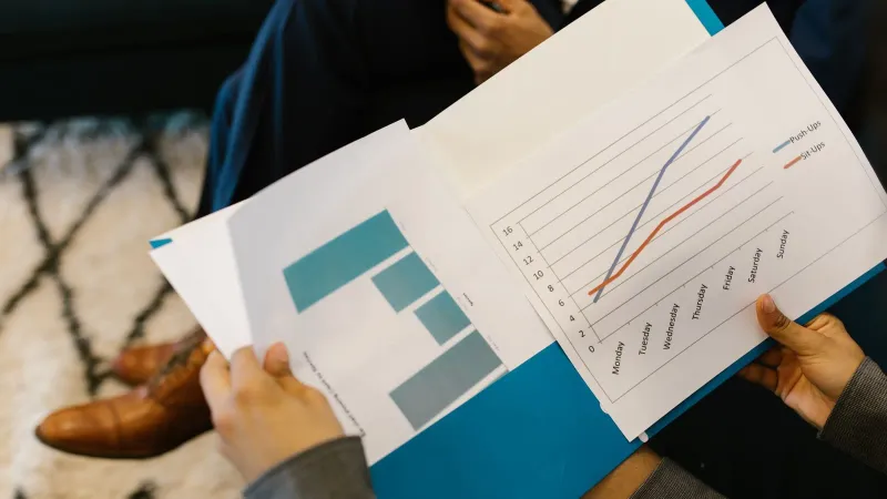 Detailed view of business reports with graphs during a corporate meeting.