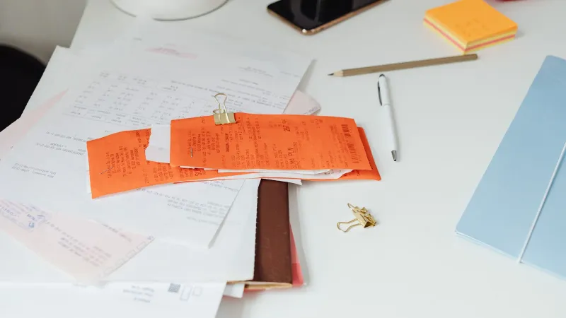 Close-up of a tidy desk with receipts, documents, and office stationery for business organization.