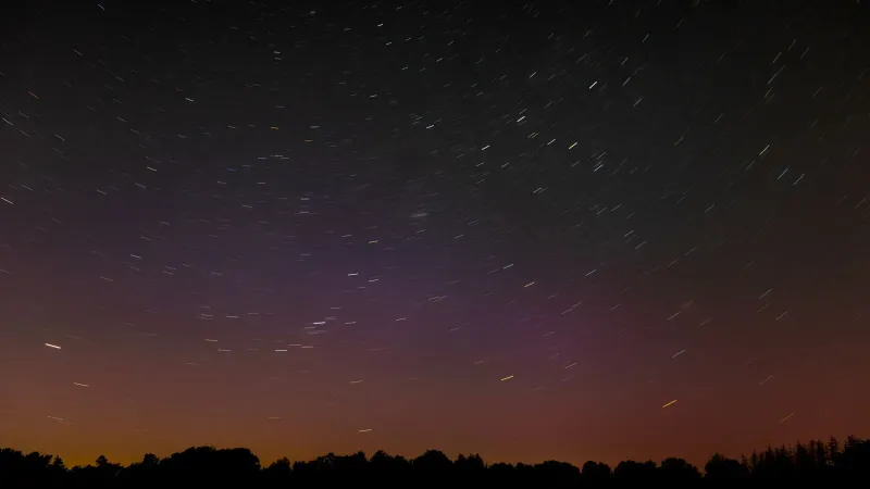 Long exposure of star trails in the night sky above rural Hamburg, Germany.