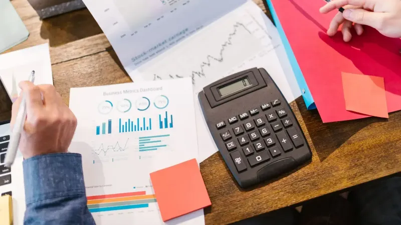 Financial analysis and planning tools with graphs and calculator on a table.