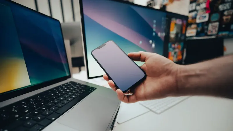 A contemporary workspace with a smartphone and laptop, showcasing modern technology in use.