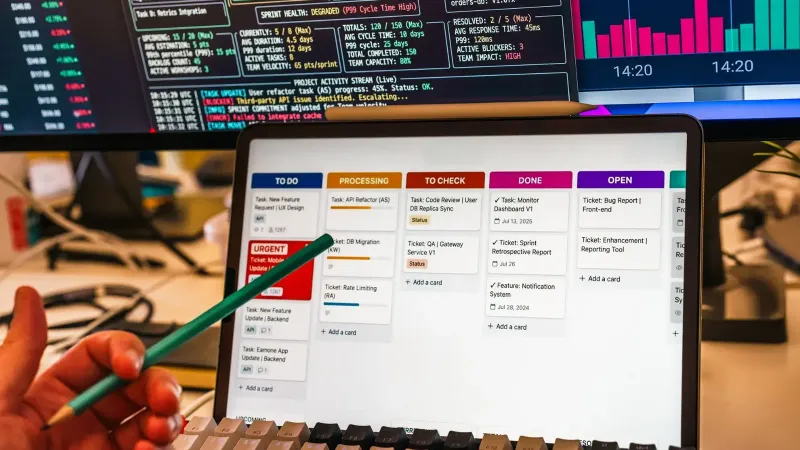 Detailed view of a business workflow setup with tablet and multiple screens displaying data charts.