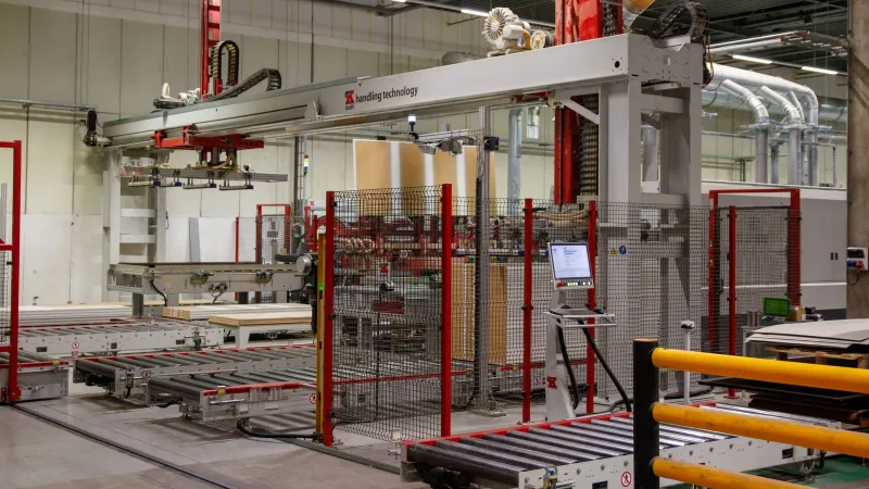 Industrial machinery with robotic arm in a modern manufacturing facility.