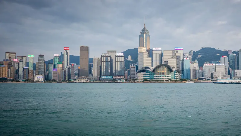 Spectacular daytime view of Hong Kong skyline with harbor in foreground.