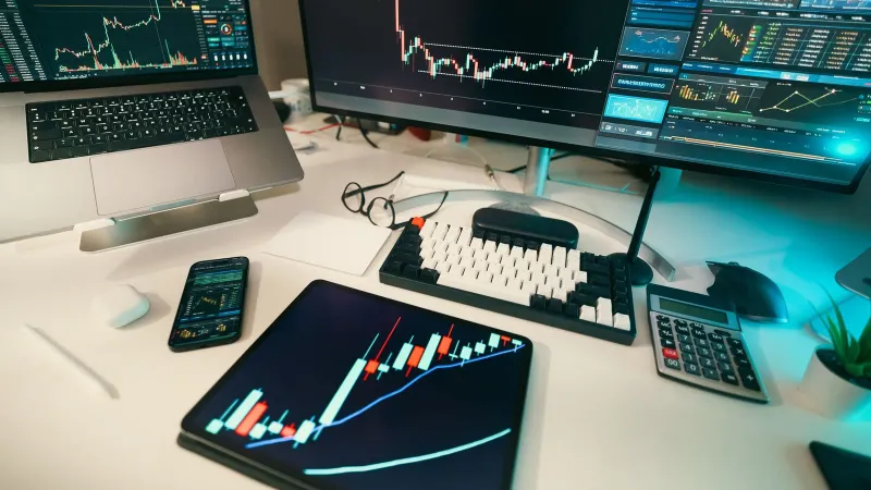 A modern trading desk with screens displaying financial charts and graphs, showcasing a digital analysis setup.