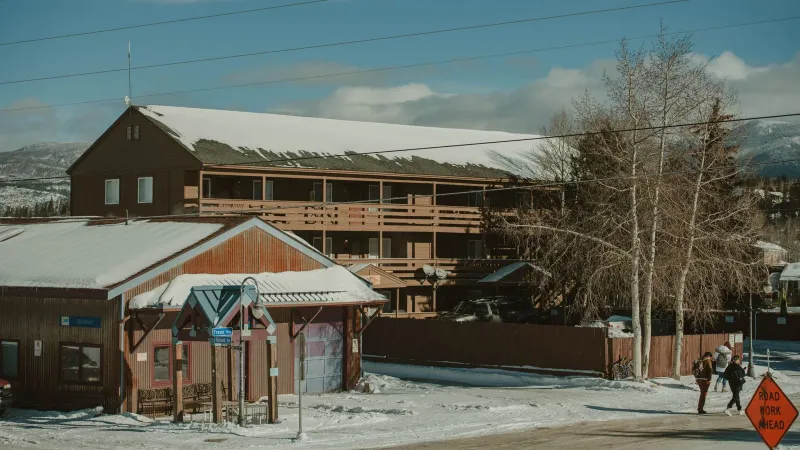 Winter scene with snow-covered rustic buildings and mountains in Colorado.