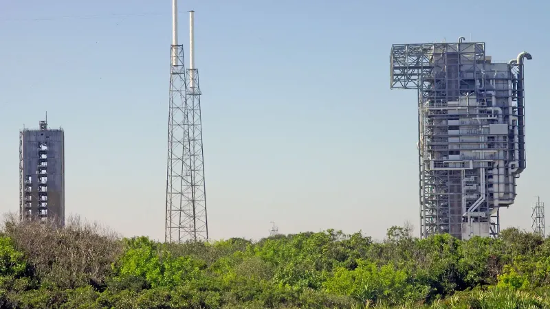 View of rocket launch gantry towers at Kennedy Space Center, Florida under clear sky.