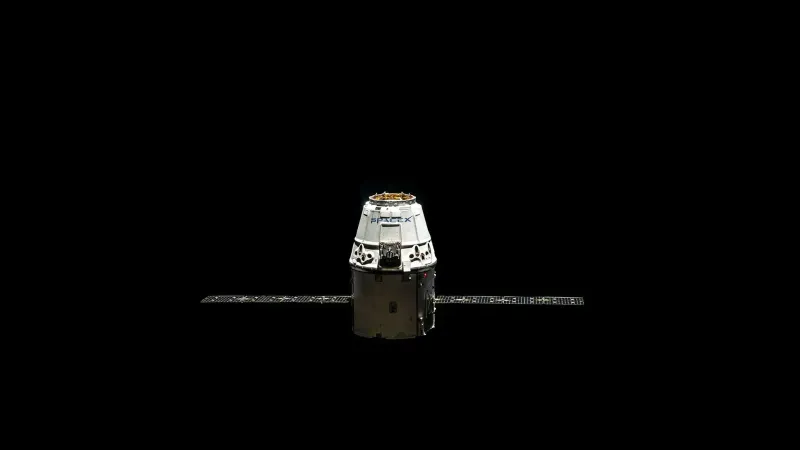 A SpaceX Dragon capsule orbited against the dark vastness of outer space.