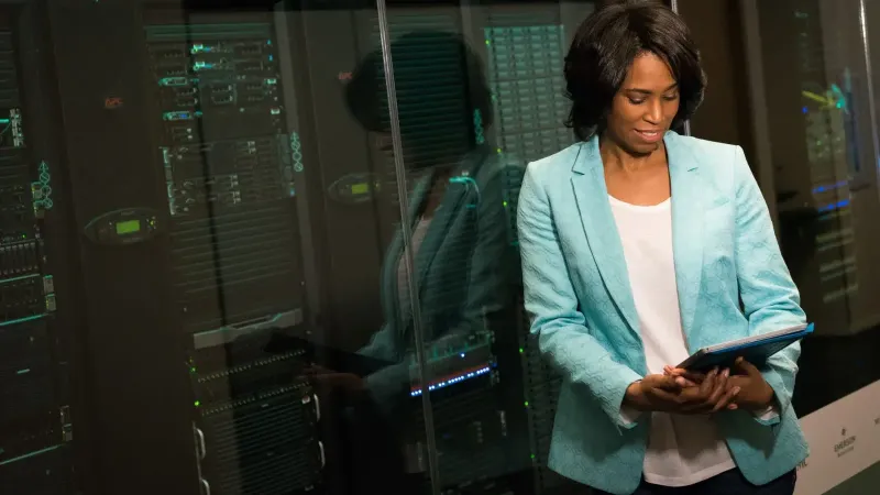 Female IT professional examining data servers in a modern data center setting.