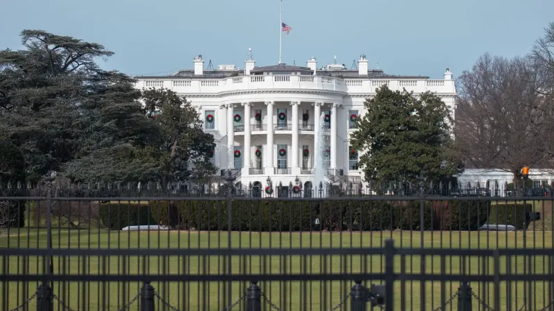 La icónica Casa Blanca con bandera americana y césped verde durante la temporada de invierno en Washington, DC.