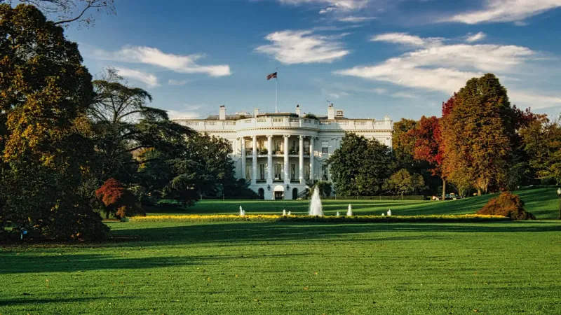 Una vista de la Casa Blanca rodeada de follaje de otoño y una fuente central en Washington, DC.