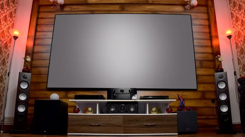 Stylish home theater featuring large screen, audio system, and decor, perfect for entertainment.