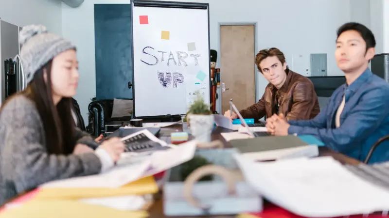 A group of young professionals brainstorming ideas in a startup office setting.