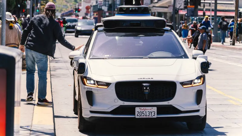 A self-driving car navigates through a bustling city street in San Francisco, capturing urban mobility in action.