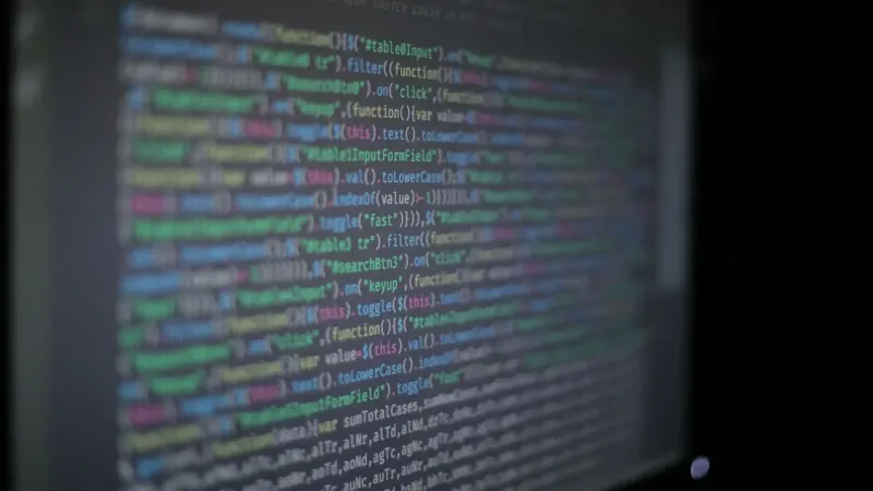 Close-up of colorful programming code on a blurred computer monitor.