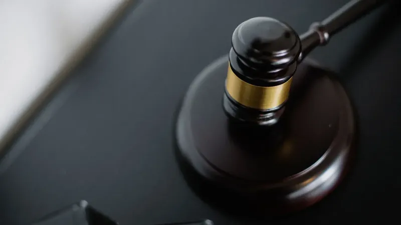 Desde arriba del mazo de madera en la superficie redonda cerca de las carpetas en la mesa en la sala del tribunal