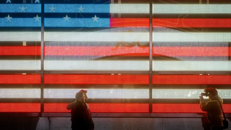 Silhouetted men posing and photographing against a neon-lit American flag background.