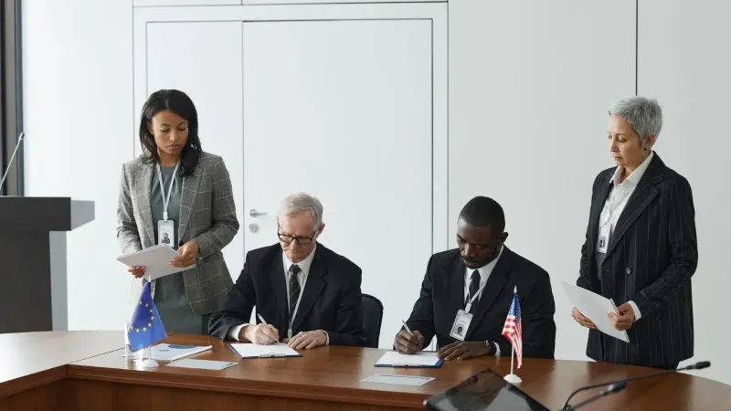 Business leaders signing a significant agreement in a conference room setting.
