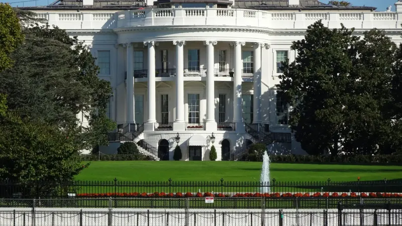 Front view of the iconic White House in Washington, DC, showing its lawn and fountain.