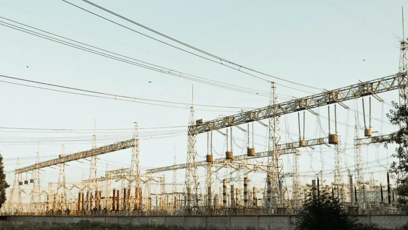 Una amplia vista de una subestación eléctrica industrial con líneas eléctricas y torres al aire libre.