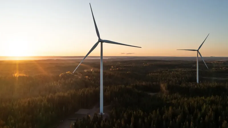 Turbinas de viento en un entorno rural con la puesta de sol detrás