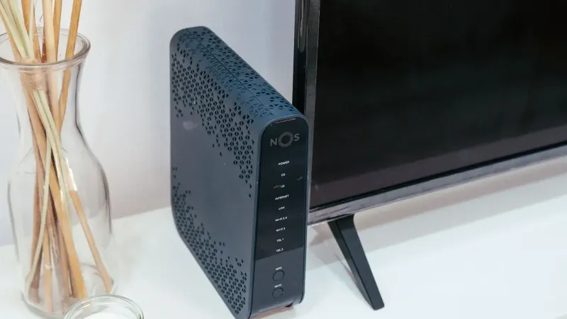 Una elegante configuración de tecnología para el hogar con un enrutador, decoración de vidrio y televisión.