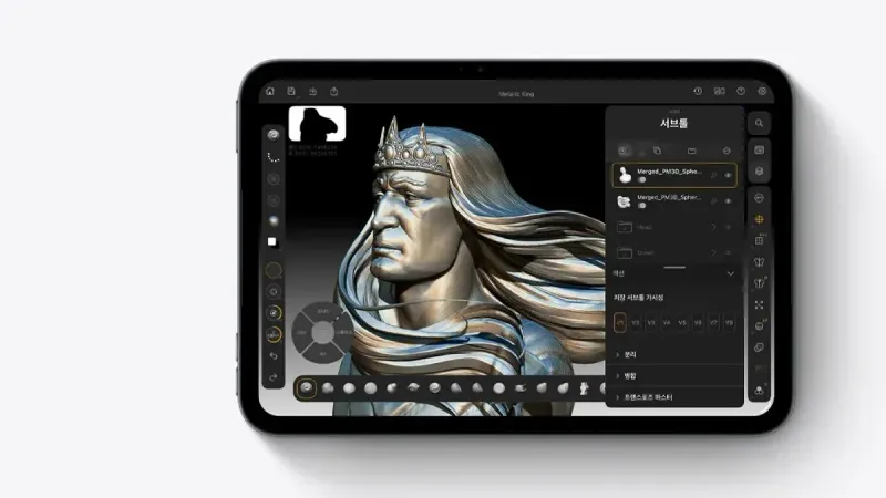 iPad mini 미드나이트 색상, 3D 랜더링 앱에 왕관을 쓰고 긴 머리에 정교한 갑옷을 입은 금속 질감 왕의 상반신 조각이 표시되어 있습니다.