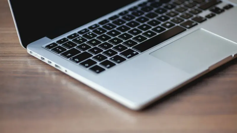 Una elegante computadora portátil en una superficie de madera, mostrando un diseño y tecnología elegantes.