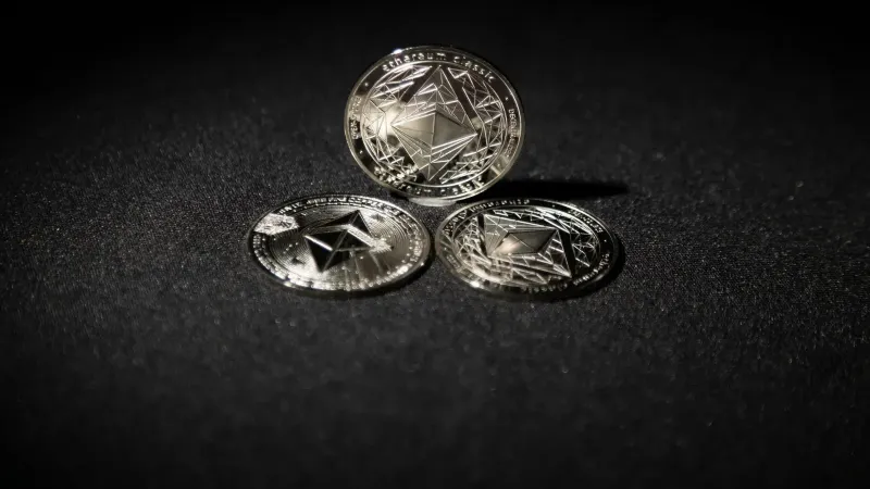 Close-up of three Ethereum coins on a dark background, showcasing digital currency themes.