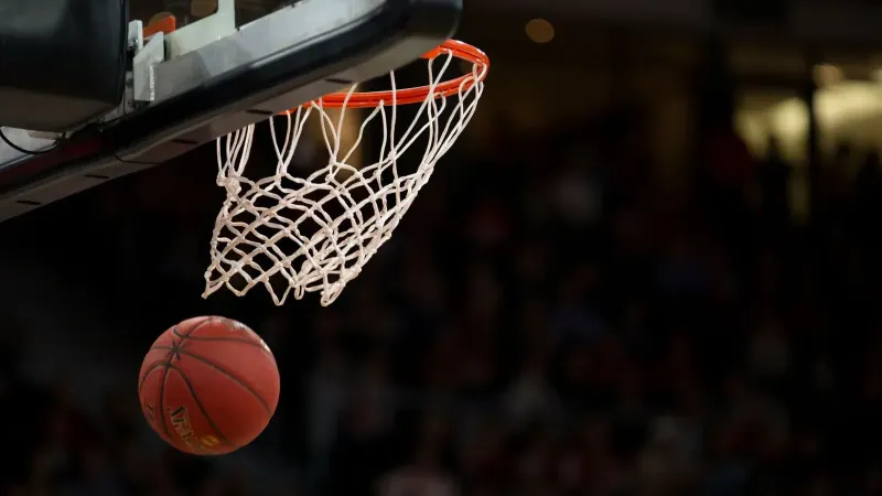 A basketball going through the hoop during a fast-paced game, capturing the excitement of the sport.