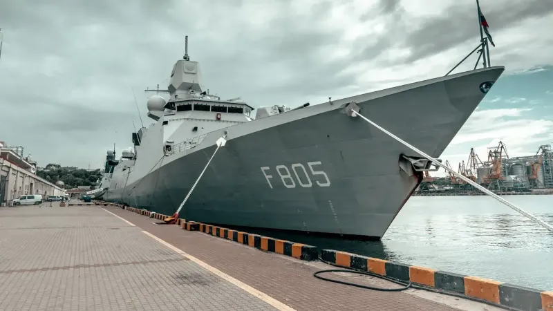 Un gran barco naval atracado en el puerto de Odessa bajo un cielo nublado, mostrando fuerza marítima.