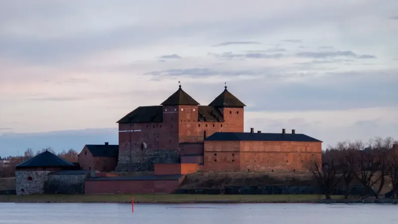 Hermosa vista del castillo medieval de Häme bajo un cielo crepuscular en Hämeenlinna, Finlandia.