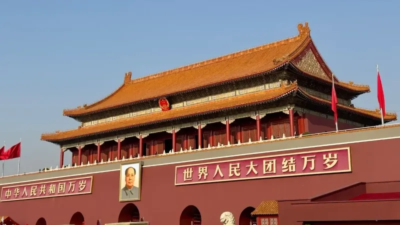 Historic Tiananmen Gate under blue skies in Beijing, China, symbolic and tourist landmark.