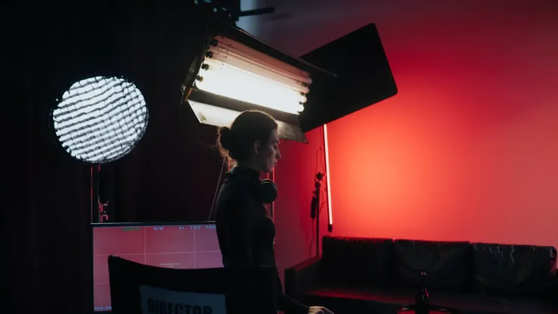Un director en un estudio con iluminación y equipamiento, creando una atmósfera cinematográfica.