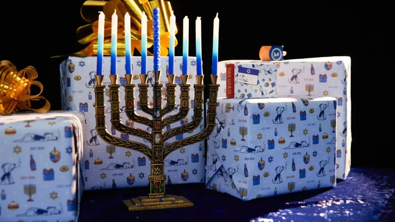 Colorful menorah with gift boxes wrapped in Hanukkah-themed paper, perfect for festive holiday vibes.