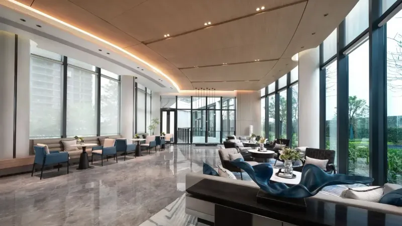 Vestíbulo de hotel de lujo espacioso y elegantemente diseñado con muebles modernos y grandes ventanales.