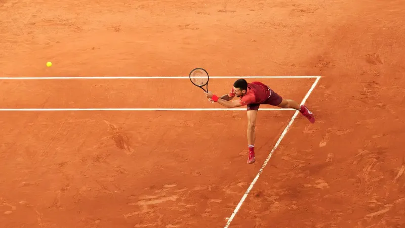 Novak Djokovic returning a serve with his backhand at the 2024 French Open (Roland-Garros), during his first round match against Pierre-Hugues Herbert (win 6/4, 7/6, 6/4) on court