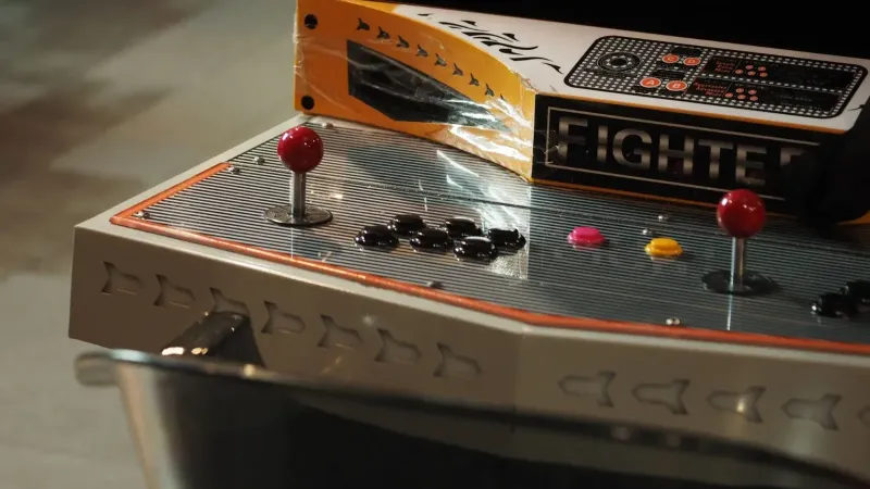 Close-up of a vintage arcade game control panel with joysticks and buttons.