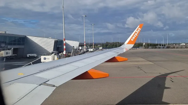 Wing view of easyJet's Airbus A320neo, registered as G-UZHW, at Amsterdam Airport Schiphol, from seat 20F.
