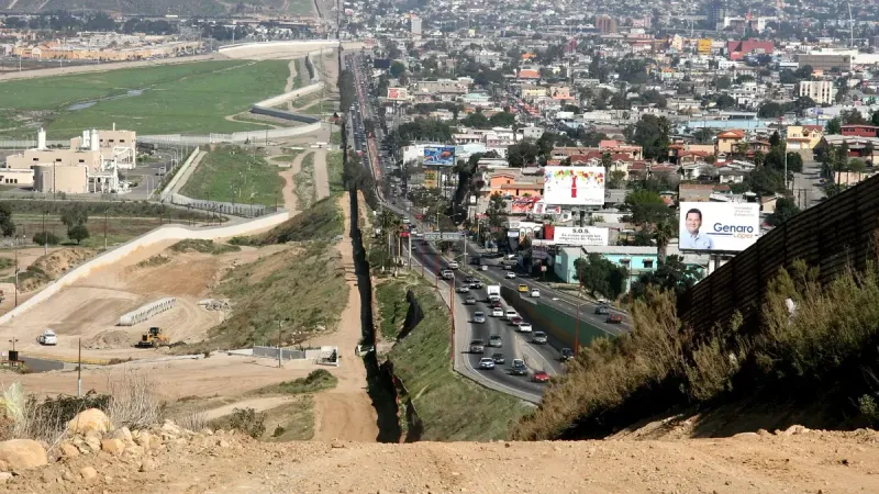 A small fence separates densely-populated Tijuana, Mexico, right, from the United States in the Border Patrol's San Diego Sector.