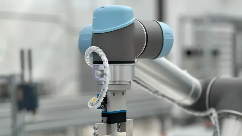 Primer plano de un brazo robótico en un entorno industrial moderno, destacando la tecnología.