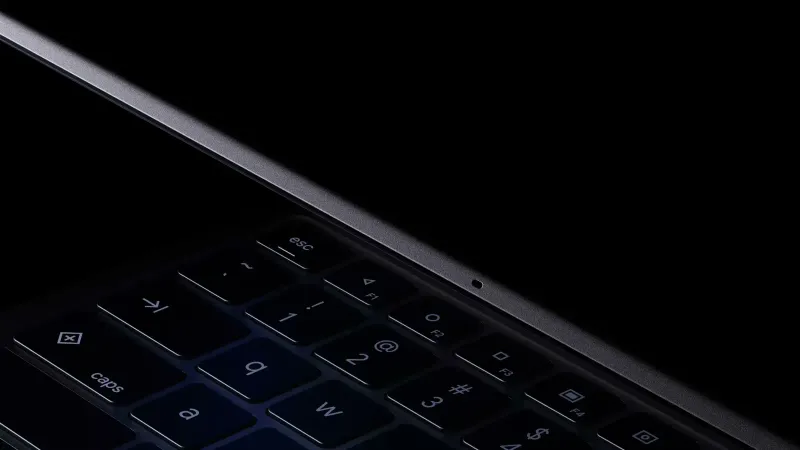 La computadora portátil Googlebook se abre lentamente, vista desde un ángulo bajo que muestra el teclado y la bisagra.