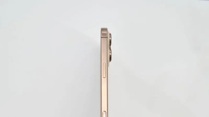 Minimalist side view of a gold smartphone on white background.